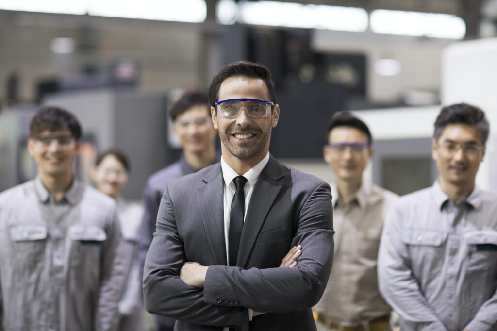 Confident businessman and engineering team in the factory